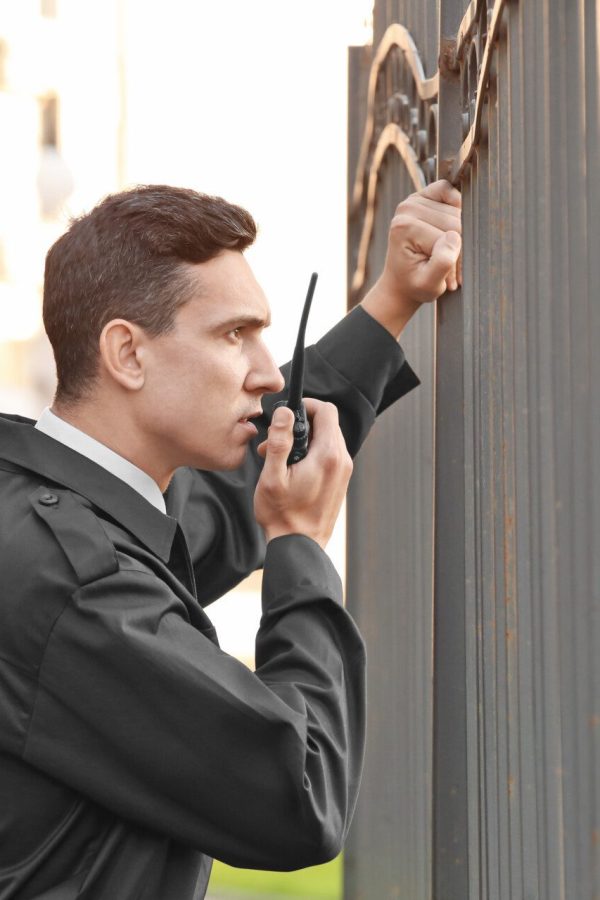 Male security guard with portable radio, outdoors